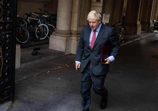 An enbattled Boris Johnson arrives in 10 Downing Street yesterday.