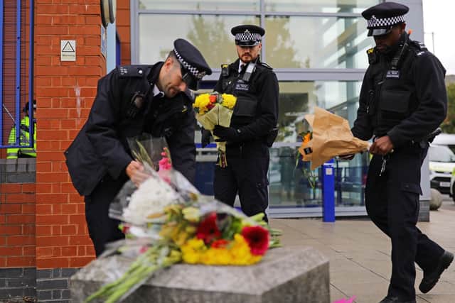 Police officers leave flowers outside Croydon Custody Centre where Sergeant Matt Ratana was killed on Friday.