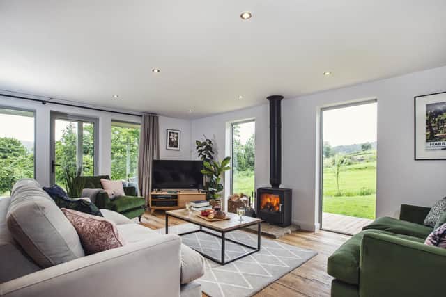 The living area with sofas from the Joules range at DFS arranged around the TV and a wood-burning stove.