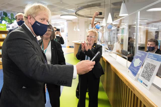 Prime Minister Boris Johnson scans his NHS Coronavirus App at Uxbridge Library during a walkabout where he met  shoppers and shopkeepers in his constituency of Uxbridge. Photo: Stefan Rousseau/PA Wire