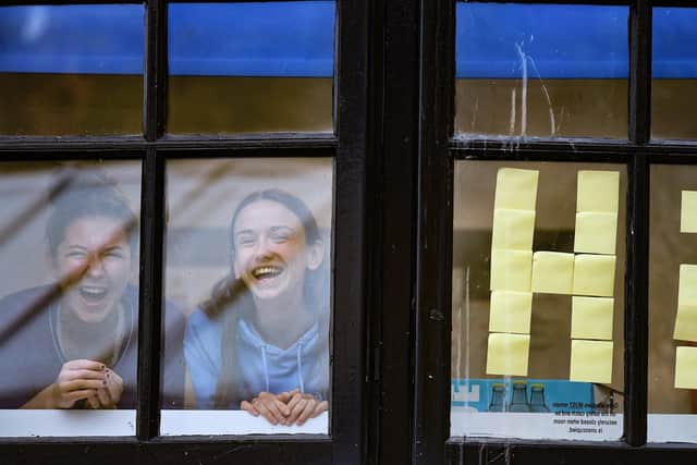 Pictured, students from Glasgow University look out of the windows of the student accommodation at Murano Street student village on September 28, 2020 in Glasgow, Scotland. Photo credit: Jeff J Mitchell/Getty Images