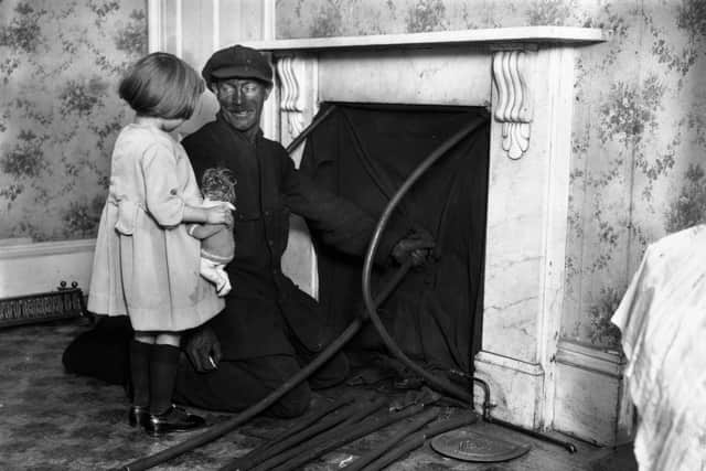 December 1923:  A little girl and a chimney sweep talking while he cleans the chimney.  (Photo by Topical Press Agency/Getty Images)