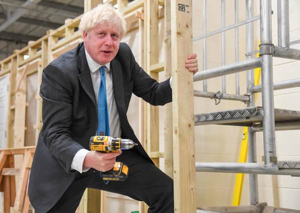 Prime Minister Boris Johnson uses a power drill during a visit to Exeter College where he delivered a speech on skills this week.