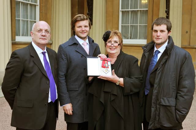 Dame Jenni Murray poses with (from the left) husband David and sons Charlie and Ed after being made a Dame Commander during an Investiture at Buckingham Palace on December 6, 2011. (Photo by John Stillwell - WPA Pool/Getty Images)