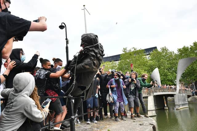 Protesters throw statue of Edward Colston into Bristol harbour during a Black Lives Matter protest rally in June this year. (PA).