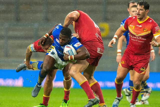 Muizz Mustapha is held by Julian Bousquet during Wednesday's Super League clash between 
Leeds Rhinos and Catalans Dragons
. Picture: Bruce Rollinson