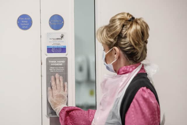Vida Grange employee Debs Bannister uses a Surfaceskins self-disinfecting door pad
