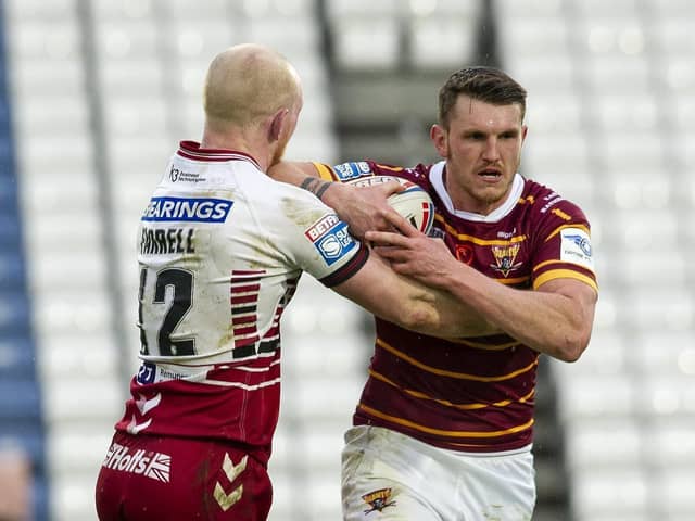 Huddersfield Giants Lee Gaskell tackled by Warriors Liam Farrell. (Picture: Tony Johnson)