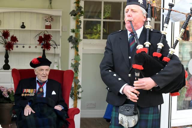 Henry McKenzie Johnston a 99 year old veteran of WW2 at the Greenwell Nursing Home in Bedale , watches Stephen Beattie a Piper with the Black Watch Association Pipe Band from Stoke on Trent playing the pipes. Image Gary Longbottom.