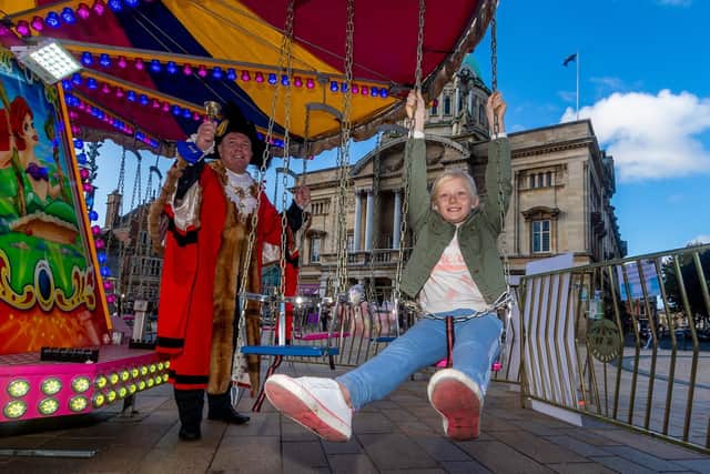 Steve Wilson, Lord Mayor of Hull, officially launching Hull Fair as Lily Young, 8, of Hull, enjoys a turn on the children's chair ride.