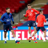 Missing out: England's Harry Winks, the unavailable Kieran Trippier and Tyrone Mings warm up. Picture: PA