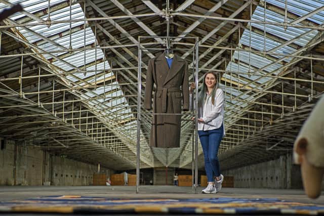 Emma Herst with her coat on display at Salts Mill, Bradford.
The University of Huddersfield student has won a Wool Week 2020 competition to design a cloth to make an overcoat, woven by Abraham Moon, inspired by one Prince Charles has worn since the 1970s. Picture Tony Johnson