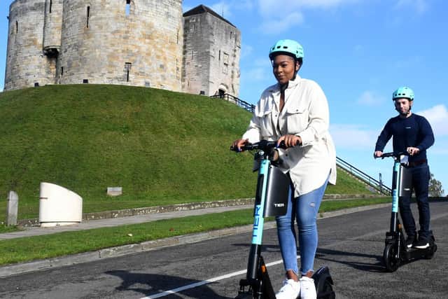 Pictured Nicole Young and Benjamin Bell from Tier electric scooters at their launch in York, passing Cliffords Tower. Photo credit: Gary Longbottom/ JPIMeida Resell