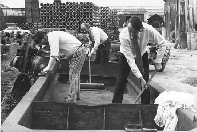 Three members of the committee responsible for the 1964 pie begin to clean a decade of grime and rust from the metal before it it treated to prevent further corrosion.