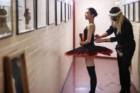 A member of the back stage staff wears PPE as she helps a ballerina from Northern Ballet prepare at Leeds Playhouse, ahead of Northern Ballet's first live performances in more than seven months. PA Photo. Danny Lawson/PA Wire