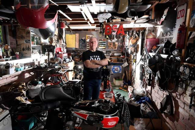 Chris Rogers in his workshop, where he has restored the old motorbike