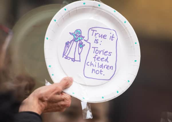 Protestors hang up paper plates carrying slogans calling for the government to extend free school meals provision, outside the Department for Education, in Westminster, London.
