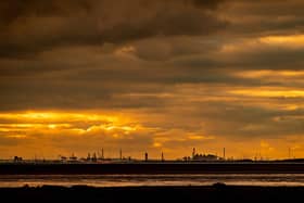 A glowing sky silhouettes the skyline of Hull's docks, and chemical plants seen from Spurn Point, East Yorkshire. Photo: James Hardisty