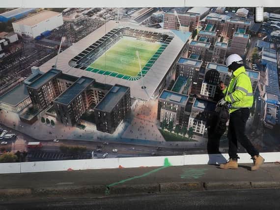 NEW BEGINNINGS: A construction worker walks past an artist's impression of Plough Lane, where Doncaster Rovers will be the first opponents