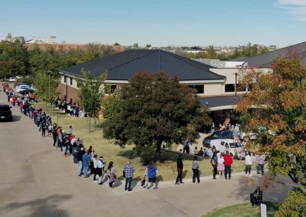 The line for early voting at a polling place in Oklahoma County wraps around Edmond Church of Christ on Friday, Oct. 30, 2020, in Edmond, Okla. People in this section of the line still have to wrap around the entire building to gain entrance to vote. Voters at the front of the line were reporting five-hour waits to vote. (AP Photo/Sue Ogrocki)
