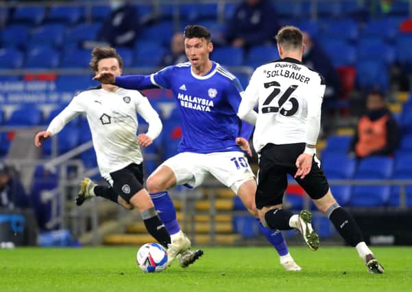 Cardiff City's Kieffer Moore (left) and Barnsley's Michael Sollbauer battle for the ball. Picture: PA