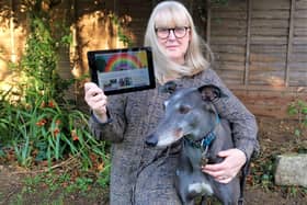 Judi Alston, with her adopted greyhound Suzi, showing a glimpse of the online Local Story collection. Photo: One to One Development Trust