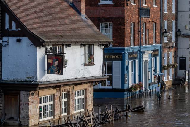 Picture James Hardisty.
Colin Fidler, Landlord of the Kings Arms, King's Staith, York, peers from his upstairs window as rising floodwater from the River Ouse is pumped out of his pub after the river overtops it's banks and floods parts on York along the river.