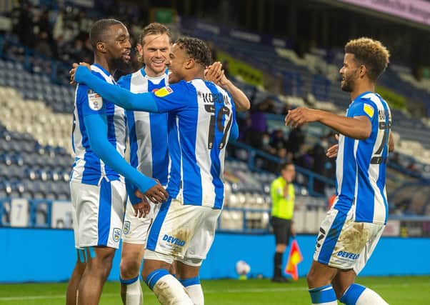 Isaac Mbenza, left,  helps Josh Koroma celebrate scoring Huddersfield's opening goal against Bristol City
 at the John Smith's Stadium on Tuesday. Picture: Bruce Rollinson