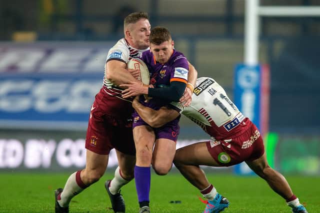 Joe Wardle is held by the Wigan line (Picture: Bruce Rollinson)