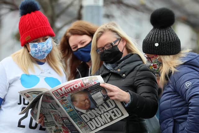 Locals read a newspaper as residents of Ballina, Co. Mayo, Ireland, begin celebrations in the ancestral home of US Presidential candidate Joe Biden