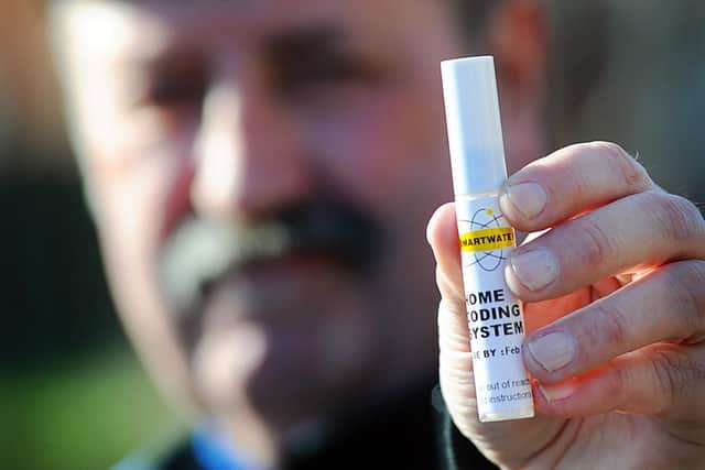 Old photo of South Yorkshire Police officer posing with a sample of SmartWater, which is used to mark items which could be targeted by criminals