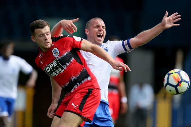 REBUILDING: Huddersfield Town's Harry Bunn in action against another former club, Bury, where he lost his job as club folded. Picture: PA