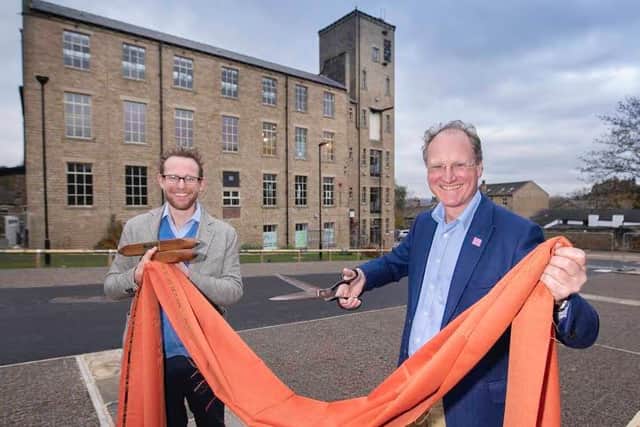John and William Gaunt hold a piece of cloth woven at Sunny Bank Mills in Farsley, where Emmerdale and Heartbeat were filmed
