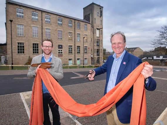 John and William Gaunt hold a piece of cloth woven at Sunny Bank Mills in Farsley, where Emmerdale and Heartbeat were filmed