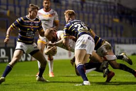 Getting to grips: Catalans Dragons' Sam Tomkins is tackled by Leeds Rhinos' Alex Sutcliffe. Picture: PA