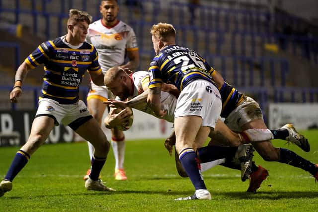 Getting to grips: Catalans Dragons' Sam Tomkins is tackled by Leeds Rhinos' Alex Sutcliffe. Picture: PA