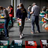 Food bank volunteers organise packed food to be boxed for people in need at a temporary food bank at Kensington Olympia in west London on April 22, 2020. (Photo by TOLGA AKMEN/AFP via Getty Images)