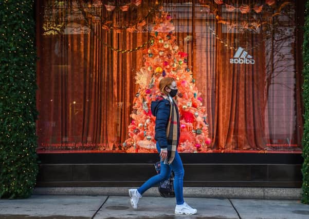 A woman wearing a face mask passes a Christmas window display on Oxford Street, London, as England continues a four week national lockdown. Picture: Kirsty O'Connor/PA Wire