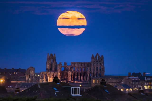 The Supermoon rises above Whitby Abbey in Yorkshire.