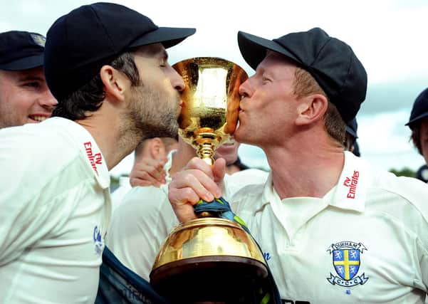 Proud moment: Graham Onions, left, and Durham captain Paul Collingwood kiss the trophy after winning the 2013 County Championship. Picture: Owen Humphreys/PA