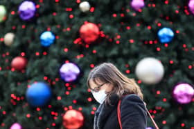 A woman walks past a Christmas tree in Trinity Leeds shopping centre in Leeds, Yorkshire, as England continues a four week national lockdown to curb the spread of coronavirus. PA