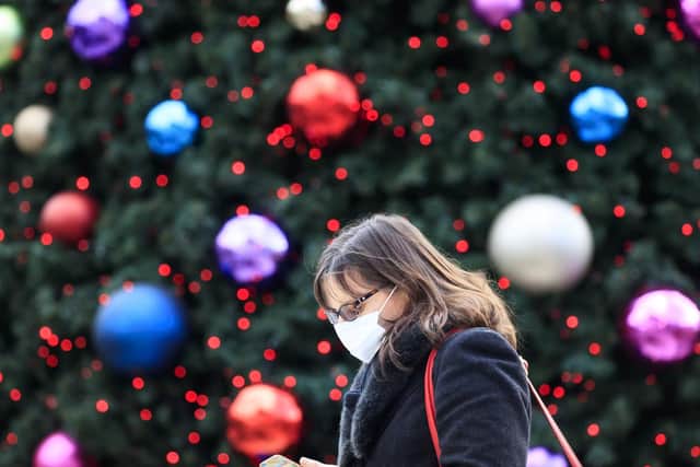 A woman walks past a Christmas tree in Trinity Leeds shopping centre in Leeds, Yorkshire, as England continues a four week national lockdown to curb the spread of coronavirus. PA