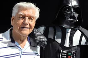David Prowse (left) who played the character of Darth Vader in the first Star Wars trilogy poses with a fan dressed up in a Darth Vader costume during a Star Wars convention in April 2013.