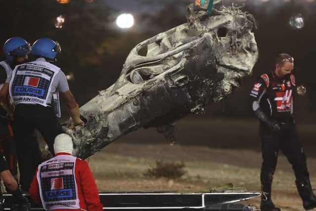 Track marshals clear the debris following the crash of Romain Grosjean. (Photo by Tolga Bozoglu - Pool/Getty Images)