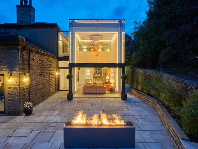 The structural glass extension by night with the outdoor fire adding extra glow