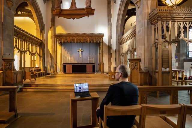 A church parishioner watches a laptop inside Liverpool Parish Church (Our Lady and St Nicholas) in Liverpool, during the Church of England's first virtual Sunday service given by the Archbishop of Canterbury earlier this year.