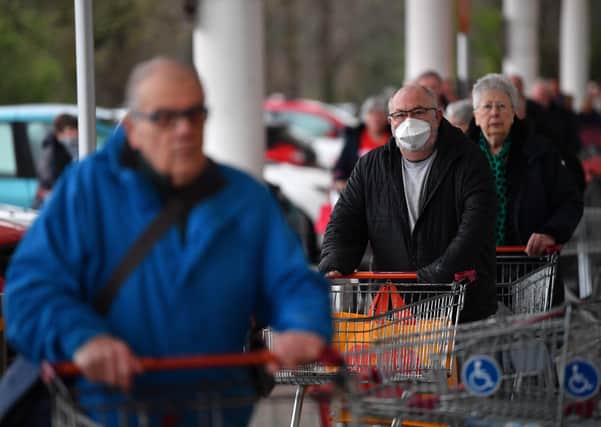 Shoppers queue outside a Sainsbury's supermarket prior to opening in Plymouth on March 19, 2020. (Photo by Dan Mullan/Getty Images)