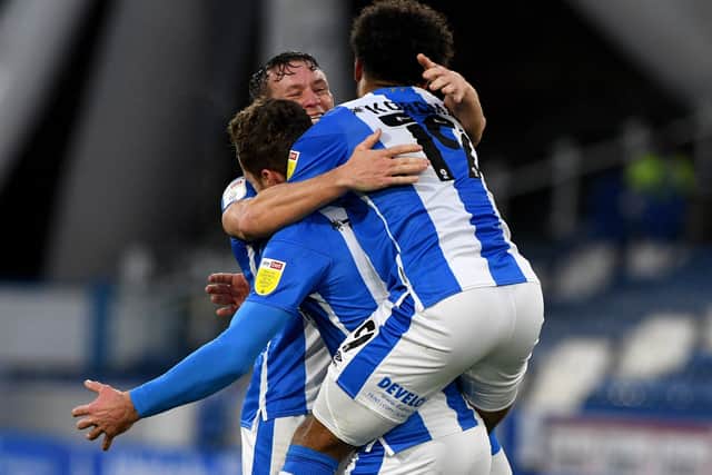 Get in: Harry Toffolo, of Huddersfield Town, is mobbed by team-mates after scoring the second goal. Picture: James Hardisty