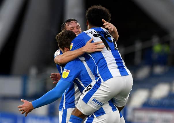 Get in: Harry Toffolo, of Huddersfield Town, is mobbed by team-mates after scoring the second goal. Picture: James Hardisty