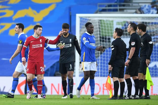 BAD CALL: Liverpool's Andrew Robertson gestures towards referee Stuart Attwell as Brighton's Danny Welbeck shakes his hand. Picture: Mike Hewitt/Getty Images